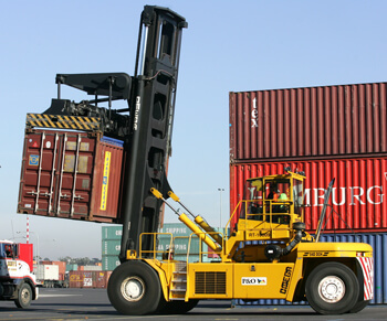 stevedoring workers fork lift driving and moving shipping container